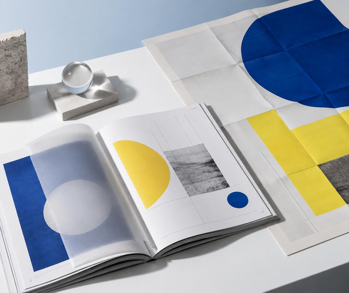 Open art journal and folded geometric exhibition poster